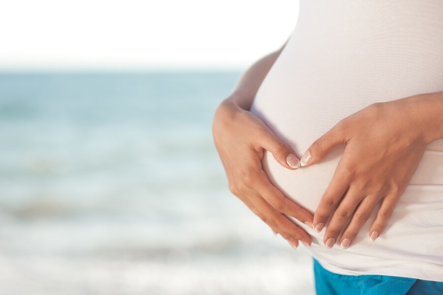 Pregnant lady's belly with hands in shape of love heart - Babymooning in Dubai