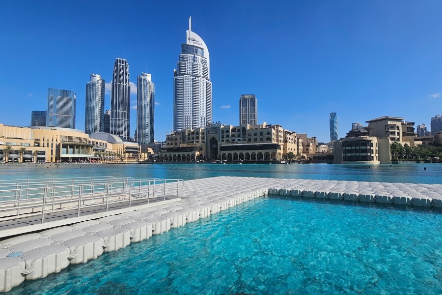 the Dubai founatin boardwalk during the day with views of burj lake
